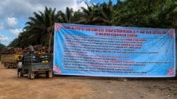 Spanduk tuntutan warga membentang di kawasan perkebunan sawit Seruyan Tengah, menyoroti sengkarut lahan eks PT BJAP, hak plasma, dan pengelolaan area sitaan negara.